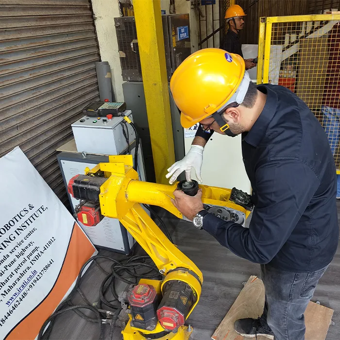 An engineer installing and calibrating an industrial robot